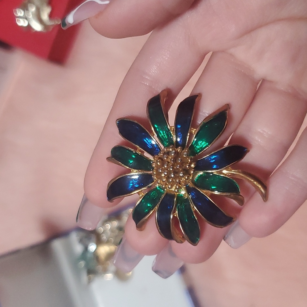 blue and green flower brooch with golden jewelled middle